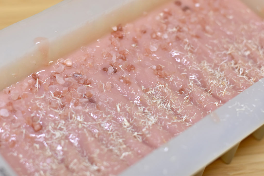 salt soap topped with loofah and large pink salt